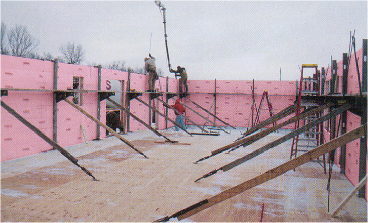 Workers are constructing a building by utilizing Fold-Form© insulated forms. Fold-Form© folds flat to ship, cutting costs for the builder and the home owner.